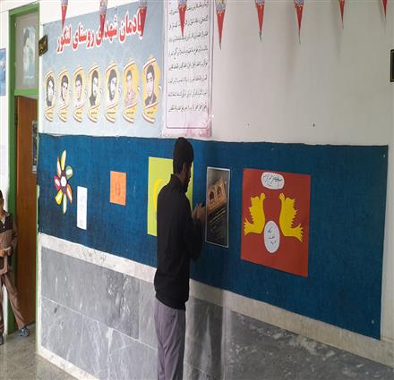 نصب پوستر جشنواره کتابخوانی رضوی در مدرسه ابتدایی شهدای لنگور